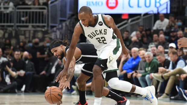 Oct 19, 2021; Milwaukee, Wisconsin, USA; Milwaukee Bucks forward Khris Middleton (22) and Brooklyn Nets guard Patty Mills (8) battle for possession of the ball in the second half at Fiserv Forum. Mandatory Credit: Michael McLoone-USA TODAY Sports